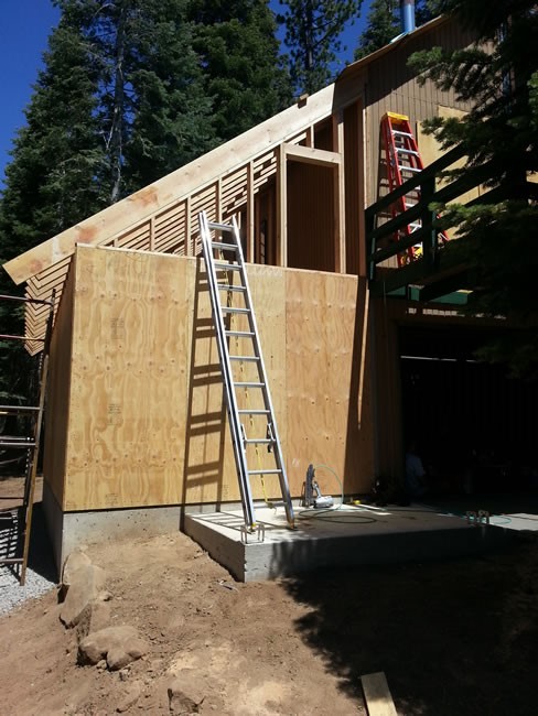 Shear wall put up around the garage.  Doorway framed for storage entrance from the deck.  Rafters in place!