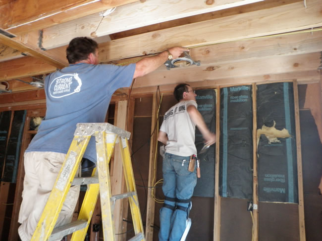Bob installing can lights and Jim installing media wires.